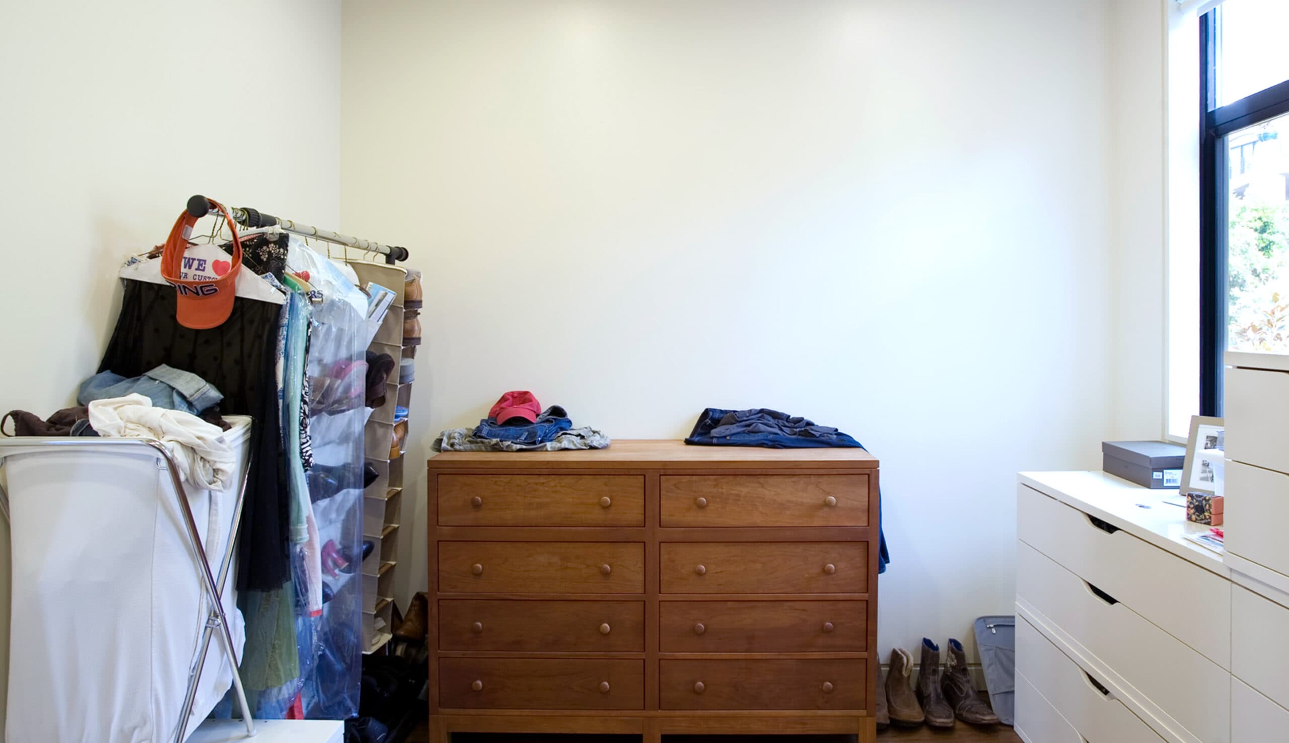 Before walk in closet space renovation, cluttered area to be redesigned by California Closets