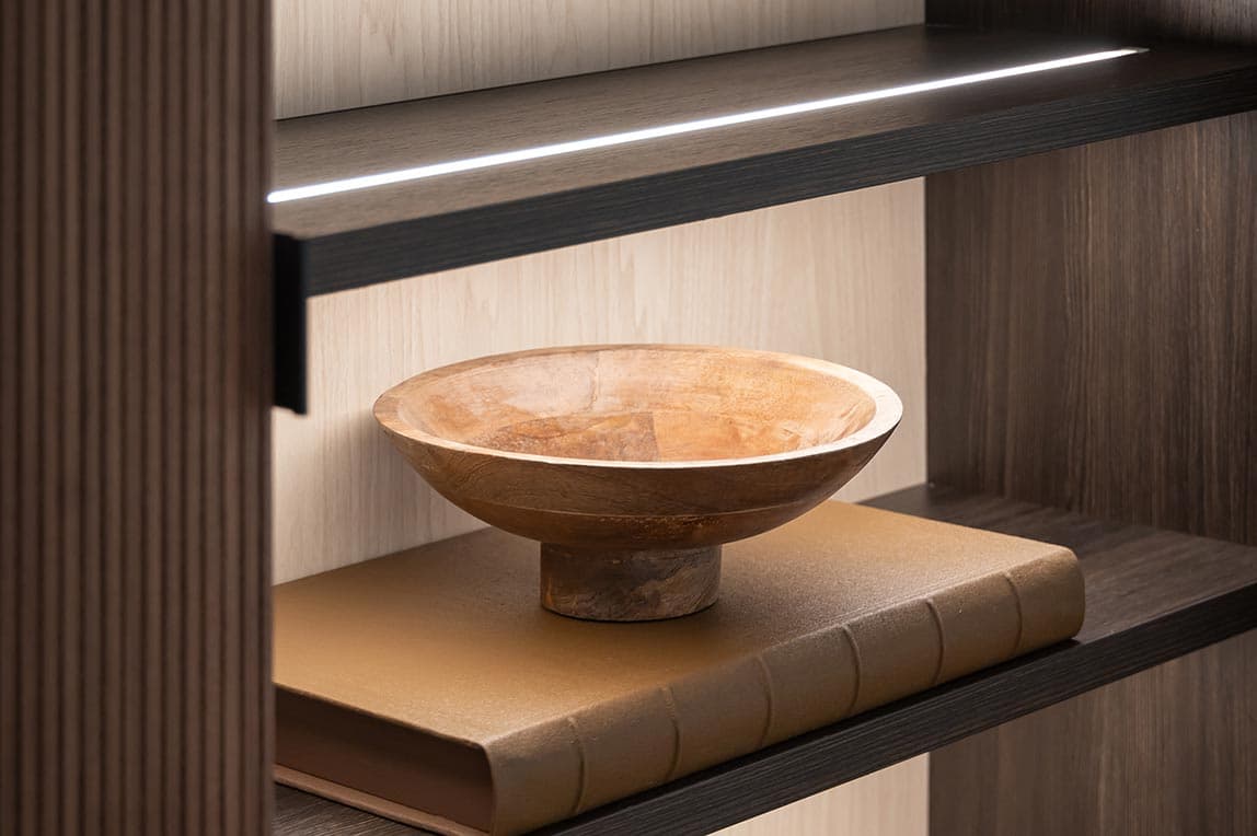 Kitchen pantry shelves with custom lighting in a soft glow by California Closets