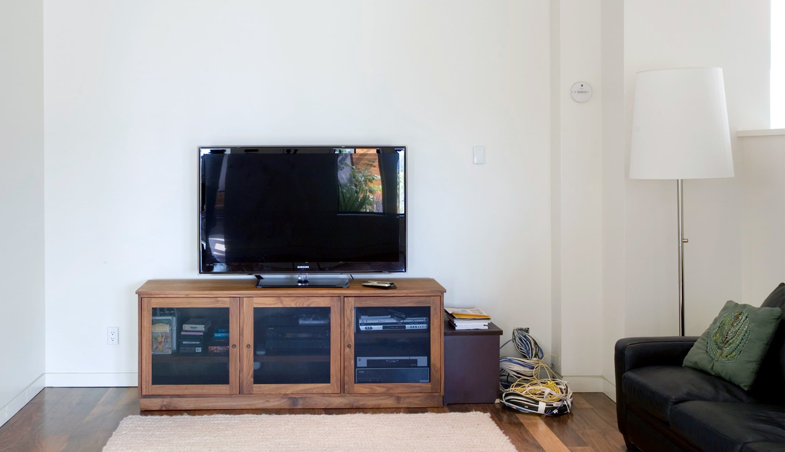 Before living area entertainment center without storage system or organizers will be installed by California Closets