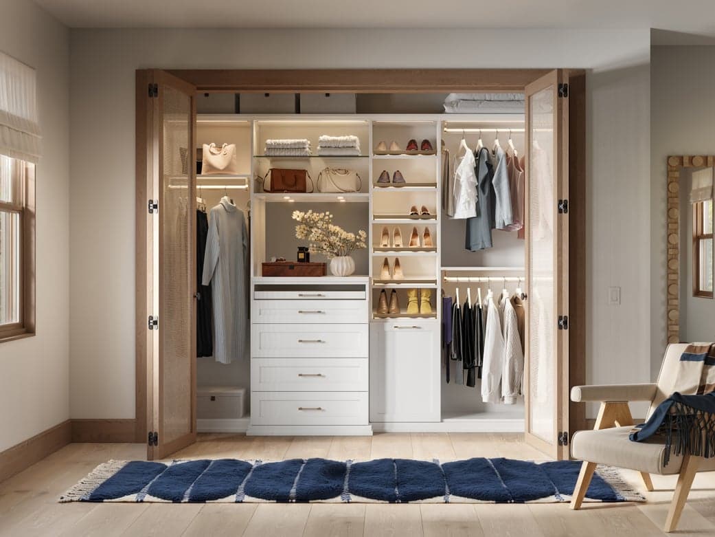 Reach in closet with built in drawers, open shelves and custom lighting by California Closets